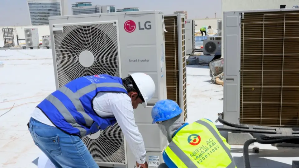 Nefal maintenance technicians inspecting an outdoor AC unit
